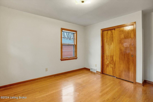 unfurnished bedroom with a closet and light hardwood / wood-style floors