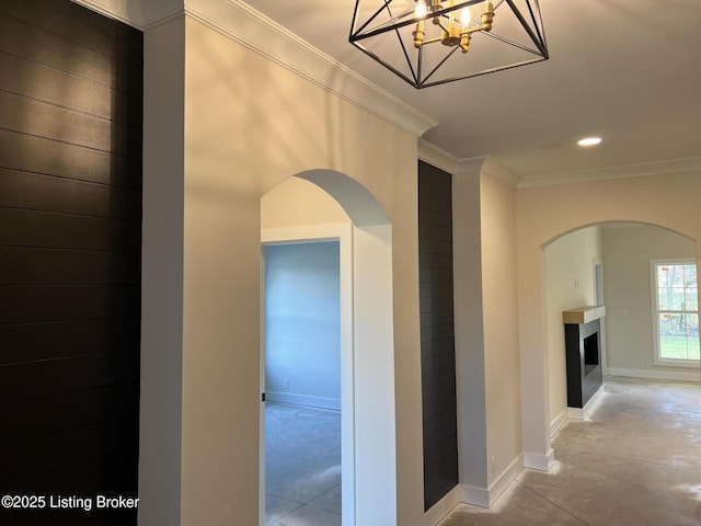 hall featuring a chandelier, crown molding, and concrete flooring