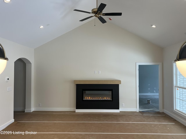 unfurnished living room featuring ceiling fan and high vaulted ceiling