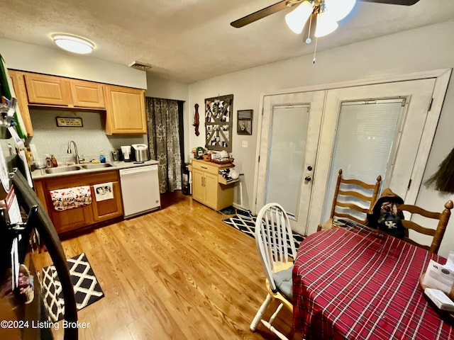 kitchen featuring french doors, light wood-type flooring, a textured ceiling, white dishwasher, and sink