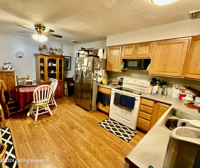 kitchen featuring white electric range, sink, a textured ceiling, light hardwood / wood-style floors, and stainless steel fridge with ice dispenser