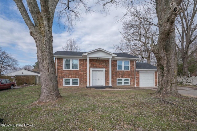 bi-level home featuring a garage and a front lawn