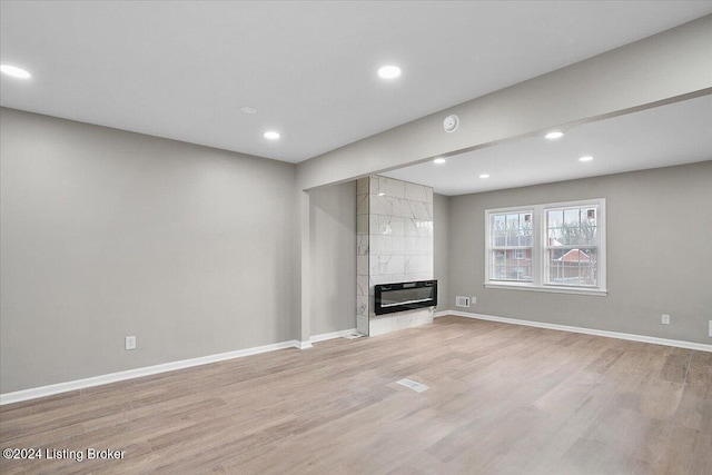 unfurnished living room with a fireplace and light hardwood / wood-style flooring