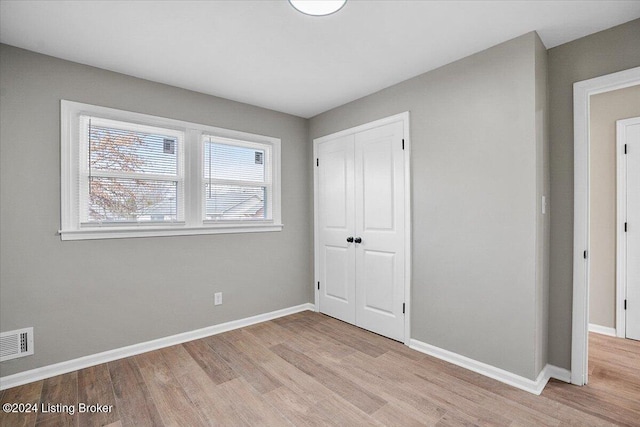 unfurnished bedroom featuring a closet and light wood-type flooring