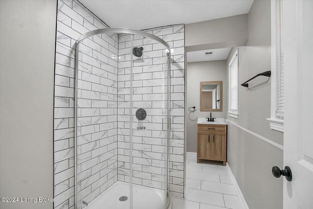 bathroom featuring tile patterned flooring, a tile shower, and vanity