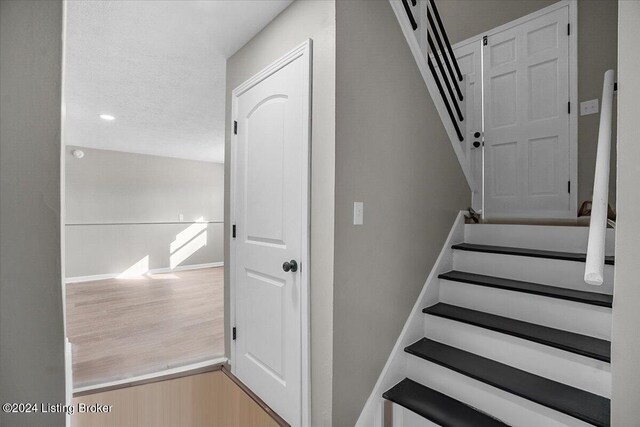 stairway featuring wood-type flooring