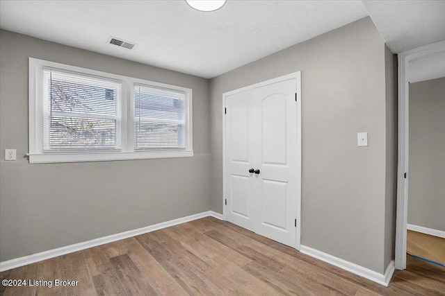 unfurnished bedroom with hardwood / wood-style floors and a closet