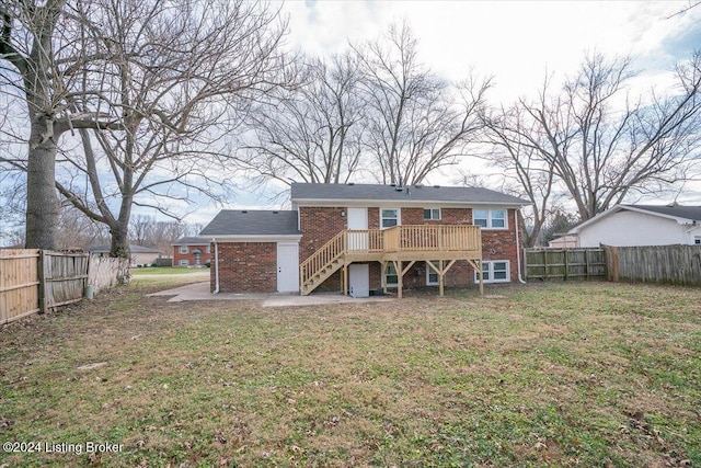 rear view of property with a deck and a lawn