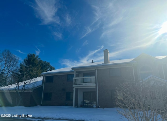 snow covered property featuring a balcony