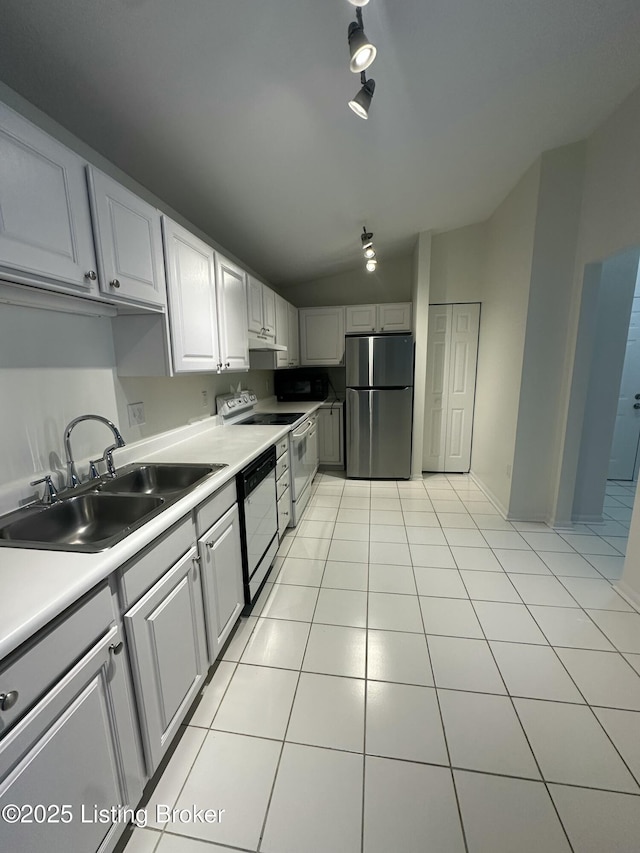 kitchen with lofted ceiling, appliances with stainless steel finishes, sink, and light tile patterned floors