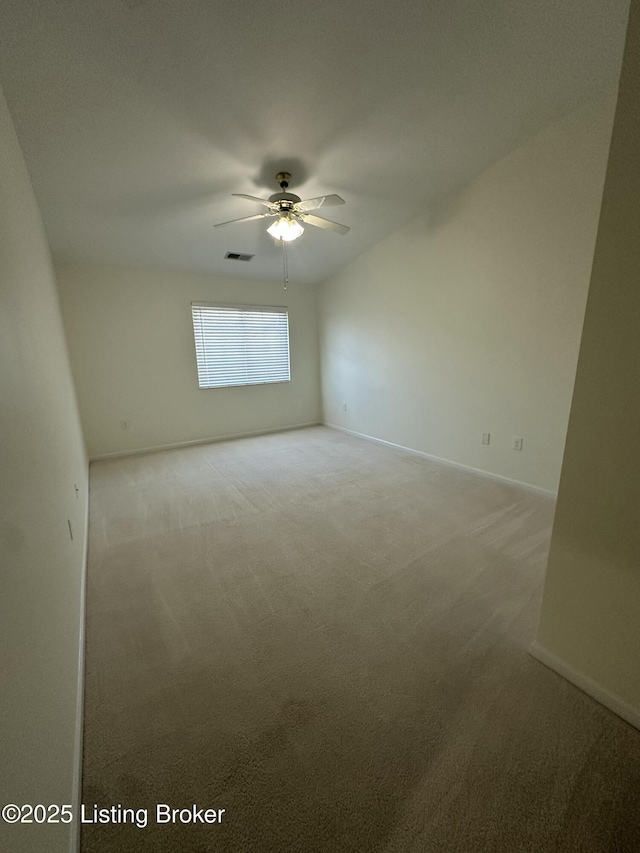 spare room with ceiling fan and light carpet