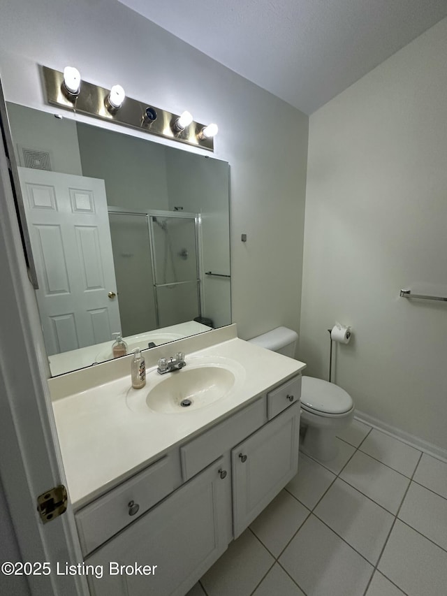 bathroom with vanity, toilet, tile patterned floors, and a shower with shower door