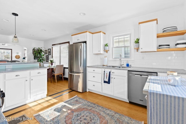 kitchen with stainless steel appliances, white cabinets, and pendant lighting