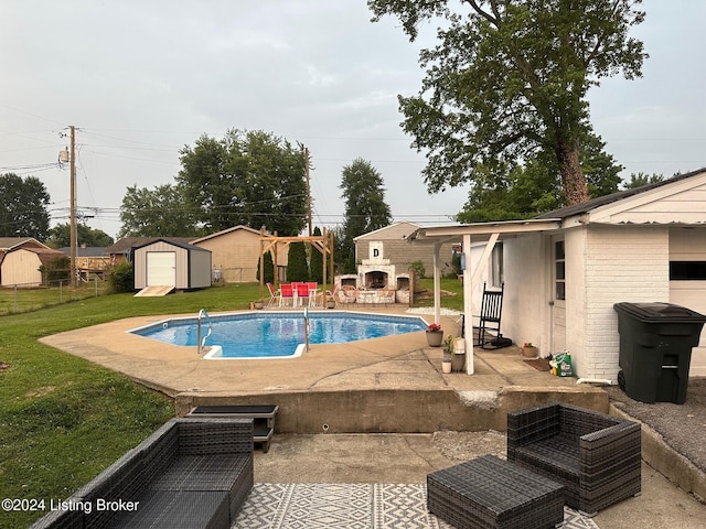 view of swimming pool featuring a patio area, a shed, a yard, and a fireplace