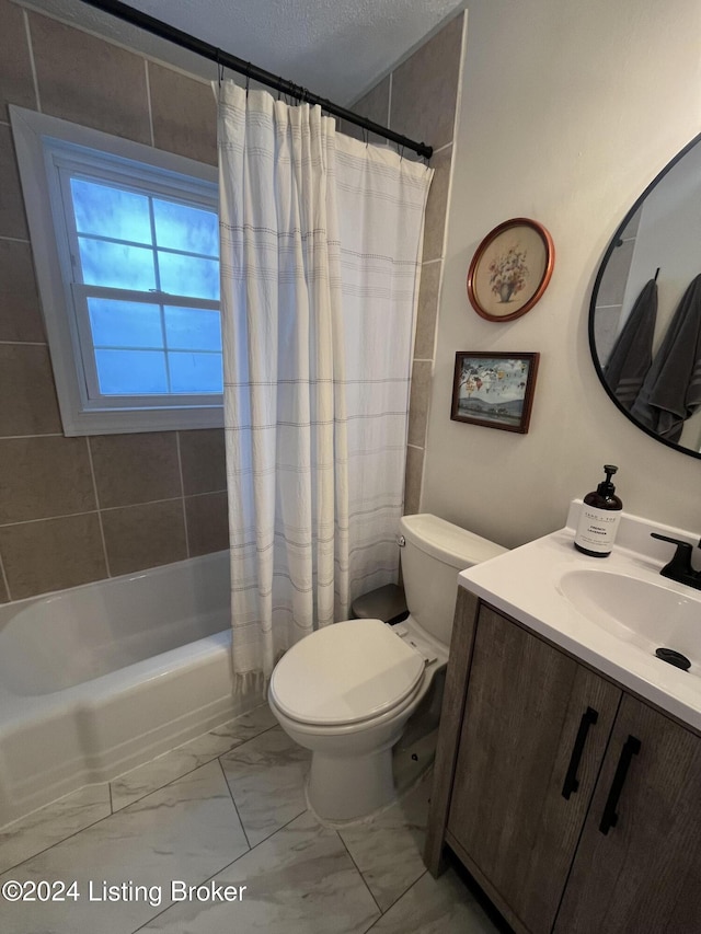 full bathroom with vanity, toilet, a textured ceiling, and shower / tub combo