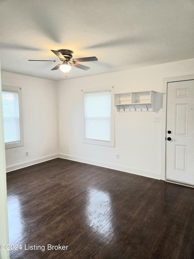 unfurnished room with a textured ceiling, ceiling fan, and dark hardwood / wood-style floors