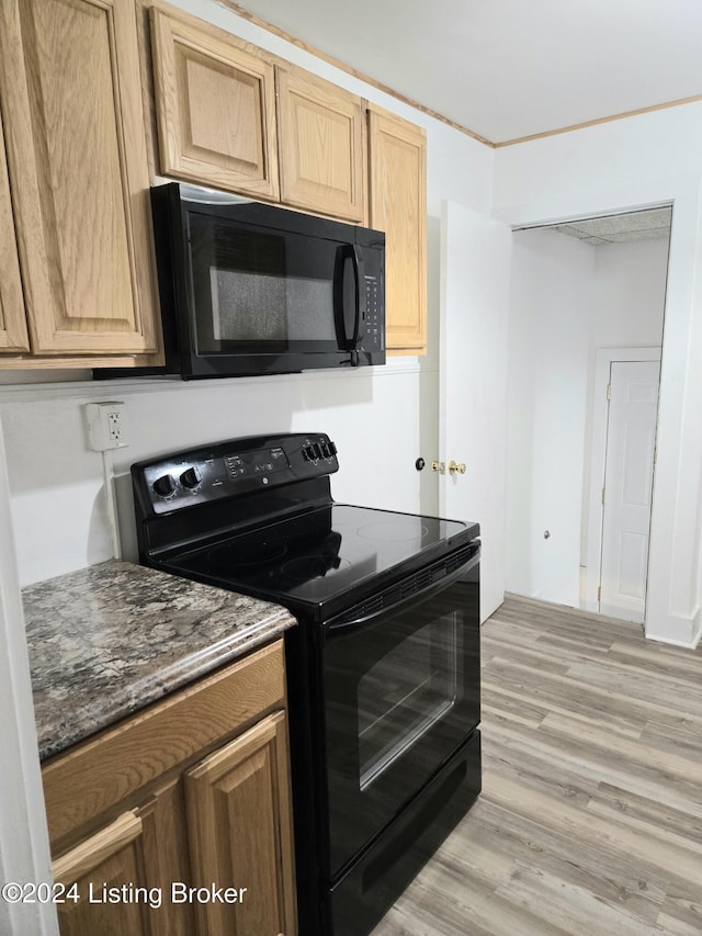 kitchen featuring black appliances, light brown cabinetry, and light hardwood / wood-style flooring