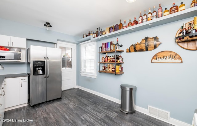 kitchen featuring dark hardwood / wood-style floors, white cabinetry, and appliances with stainless steel finishes