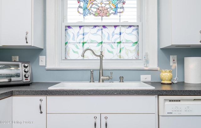 kitchen with white cabinets, white dishwasher, and sink