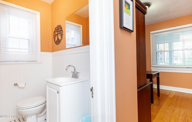 bathroom with toilet, vanity, and hardwood / wood-style flooring