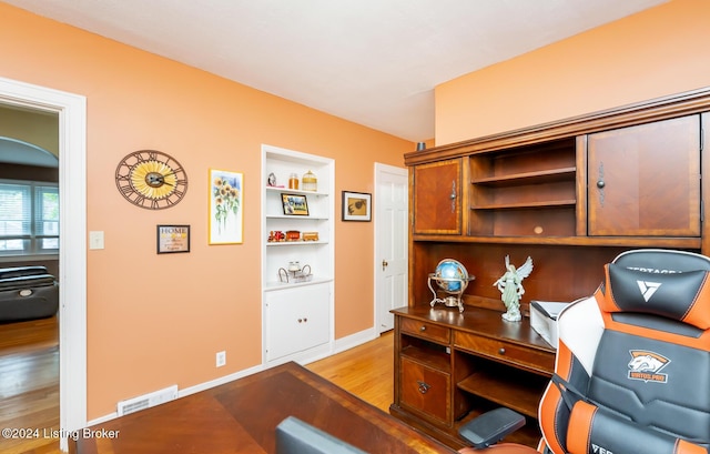 office area with built in features and light hardwood / wood-style flooring