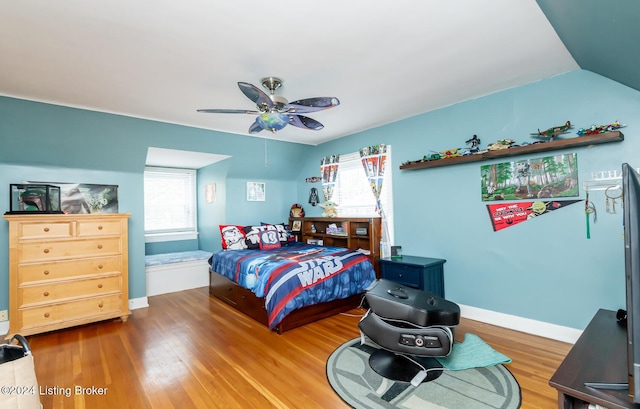 bedroom with hardwood / wood-style floors, ceiling fan, and vaulted ceiling