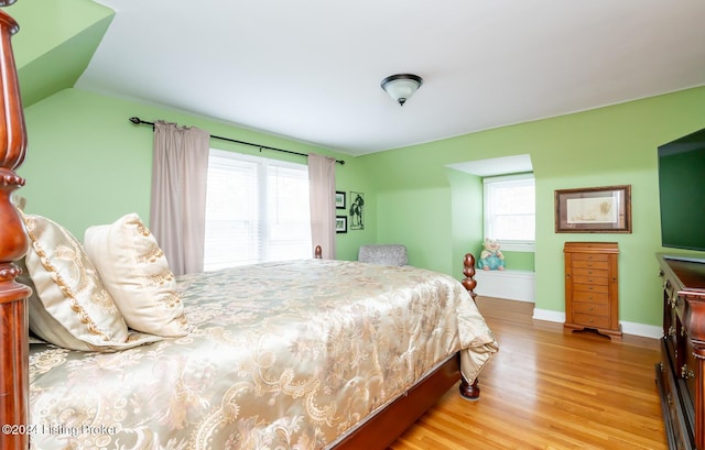 bedroom with light hardwood / wood-style flooring and multiple windows