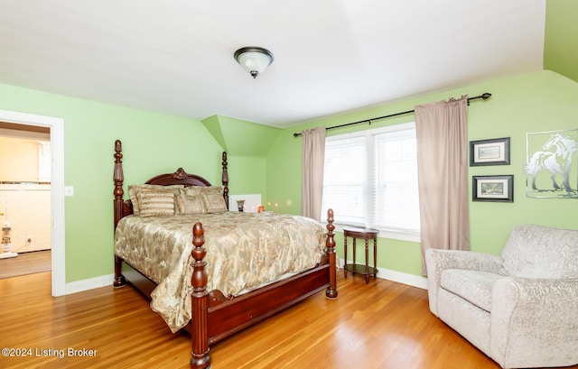 bedroom with hardwood / wood-style floors and lofted ceiling