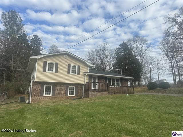 tri-level home with a porch, a front lawn, and central air condition unit