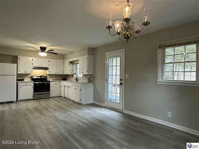 kitchen with sink, white refrigerator, stainless steel electric stove, white cabinets, and ceiling fan with notable chandelier