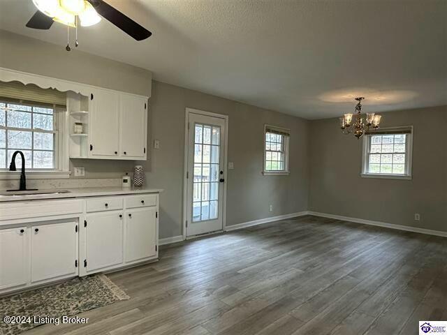 kitchen featuring white cabinets, a wealth of natural light, hanging light fixtures, and sink