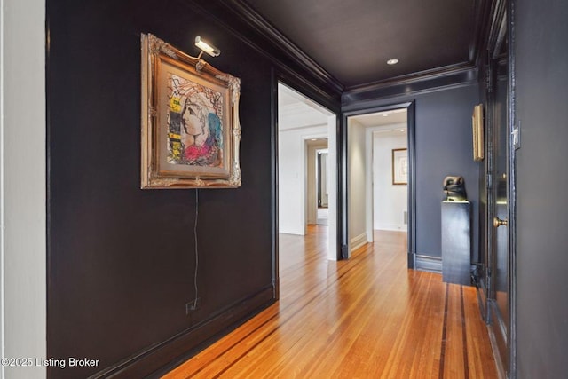 corridor with wood-type flooring and crown molding