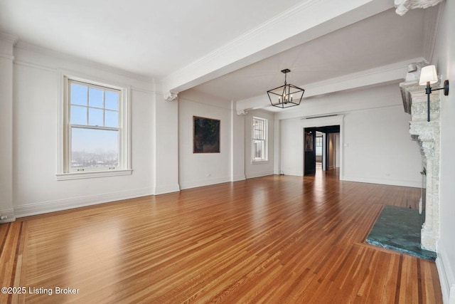 unfurnished living room with wood-type flooring, an inviting chandelier, and ornamental molding