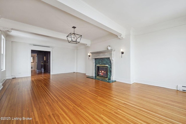 unfurnished living room with hardwood / wood-style flooring, ornamental molding, beam ceiling, and a fireplace