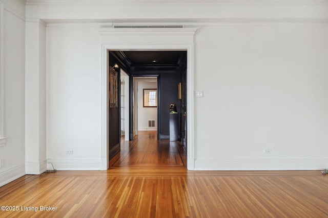 spare room with ornamental molding and hardwood / wood-style flooring