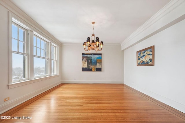 unfurnished dining area with light wood-type flooring, an inviting chandelier, and ornamental molding