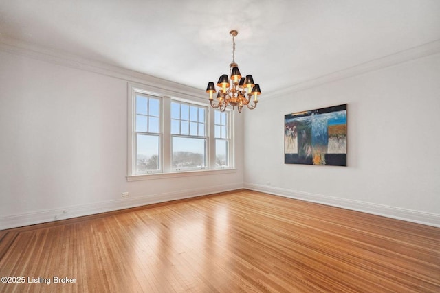 empty room with light hardwood / wood-style flooring, a chandelier, and ornamental molding