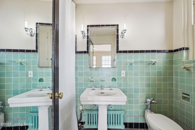 bathroom with toilet, tile walls, and radiator heating unit