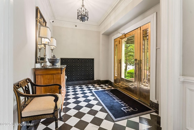 foyer entrance featuring ornamental molding and a notable chandelier