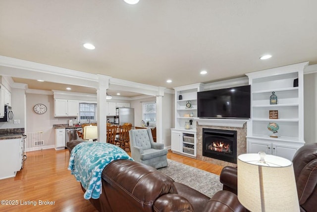 living room with ornamental molding and light hardwood / wood-style flooring