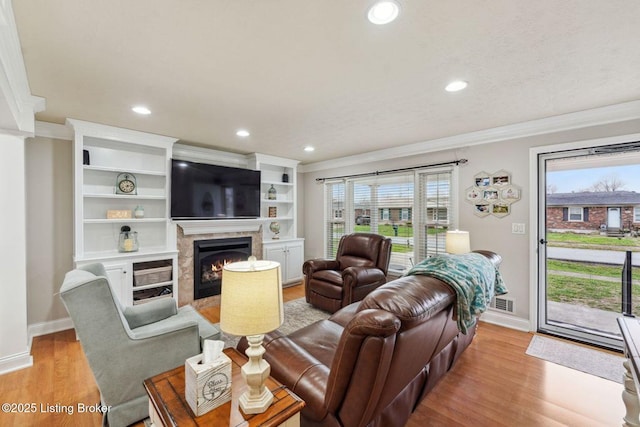 living room featuring plenty of natural light, light hardwood / wood-style floors, and crown molding