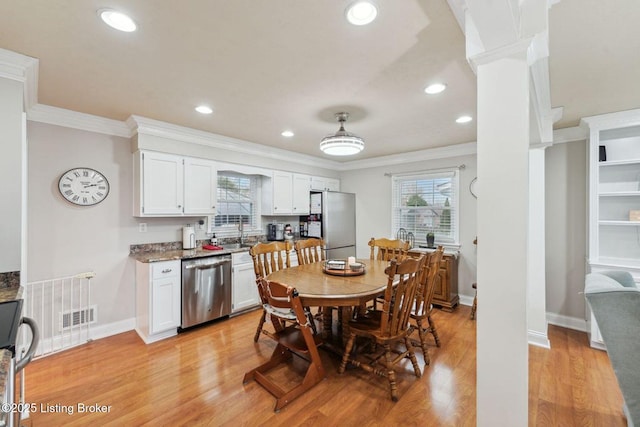 dining space with sink, light hardwood / wood-style floors, and ornamental molding