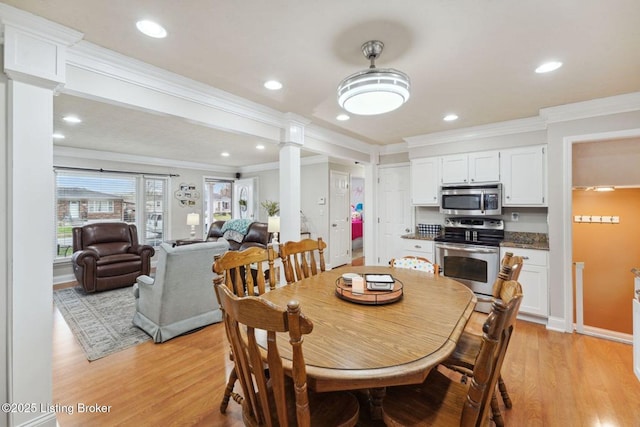 dining space featuring decorative columns, crown molding, and light hardwood / wood-style flooring