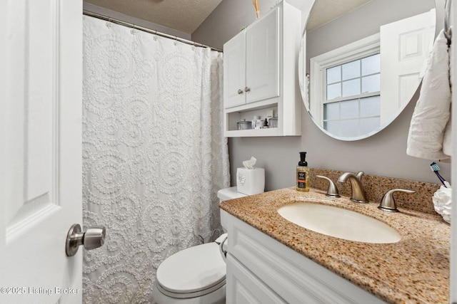 bathroom with vanity, toilet, and a textured ceiling