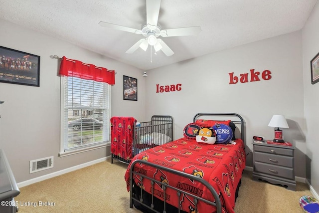 bedroom featuring carpet, ceiling fan, and a textured ceiling