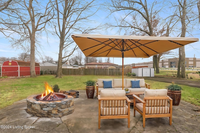 view of patio featuring an outdoor living space with a fire pit and a storage shed