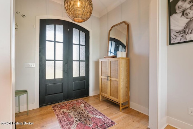 entryway featuring crown molding, a healthy amount of sunlight, french doors, and wood-type flooring