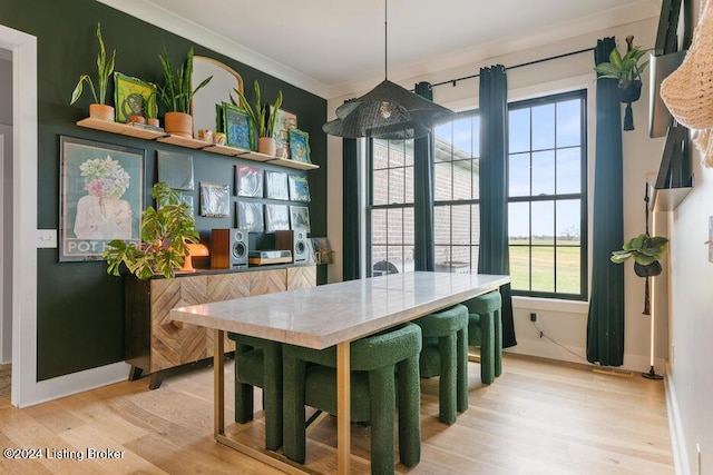 dining room featuring hardwood / wood-style flooring and crown molding