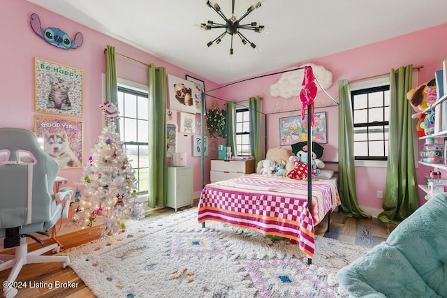 bedroom featuring wood-type flooring and a notable chandelier