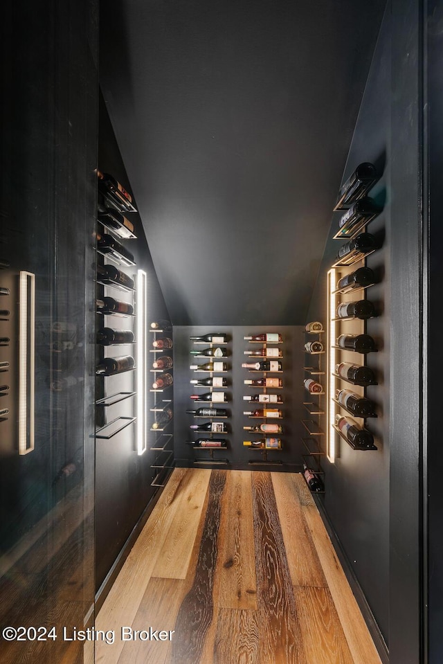 wine area featuring hardwood / wood-style floors and vaulted ceiling